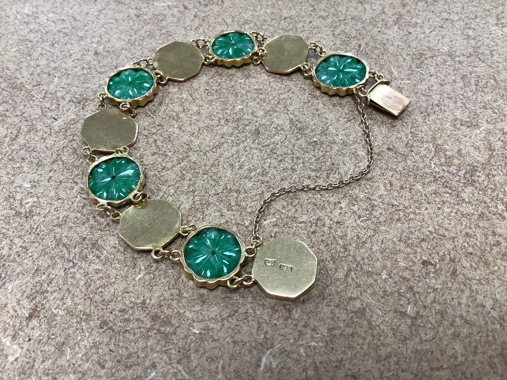 A Chinese yellow metal (stamped WH 20) and carved jadeite disc set bracelet, 18cm, gross 19 grams.